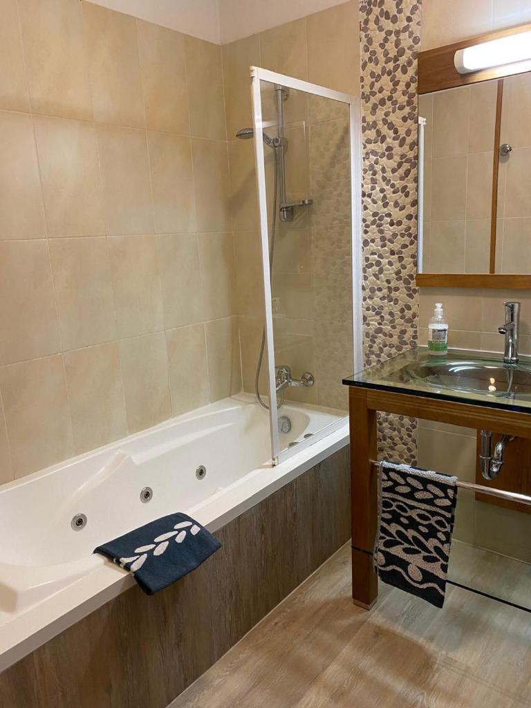 une salle de bain avec une baignoire et un lavabo dans l'établissement Appartement tout confort - Belle vue sur le Cambre d'Aze, à Bolquère-Pyrénées 2000
