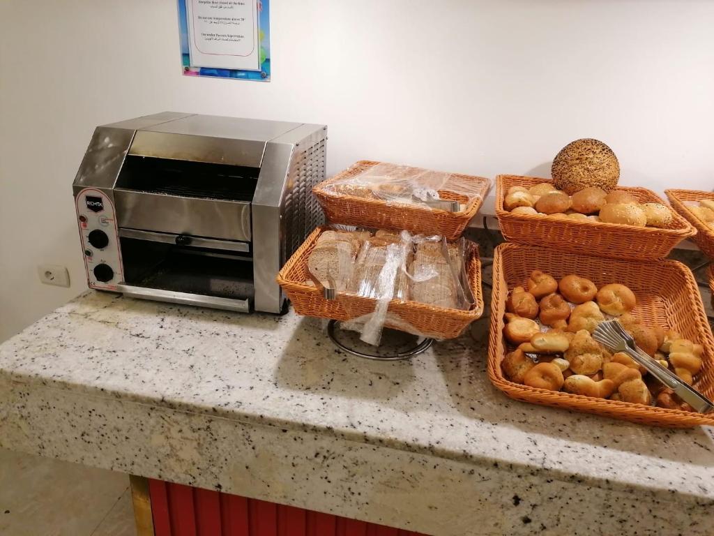 un comptoir avec des paniers à pain et un micro-ondes dans l'établissement RESORT VILLAGE AQUA MARINA FAMILY - Daily Rooms Tidying - CocktailsBar- Pet Friendly - with Hypermarket - Delivery Restaurant-Pizzeria - Room Breakfast with supplement - Ultra Fast Wi-Fi - Play Area for children - Olympic Swimming Pool - Parking, à Caorle