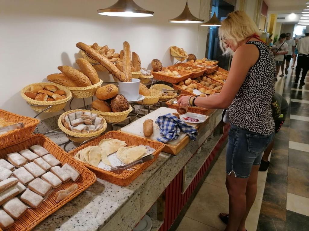 une femme debout devant le comptoir d'une boulangerie dans l'établissement RESORT VILLAGE AQUA MARINA FAMILY - Daily Rooms Tidying - CocktailsBar- Pet Friendly - with Hypermarket - Delivery Restaurant-Pizzeria - Room Breakfast with supplement - Ultra Fast Wi-Fi - Play Area for children - Olympic Swimming Pool - Parking, à Caorle 287 autres photos