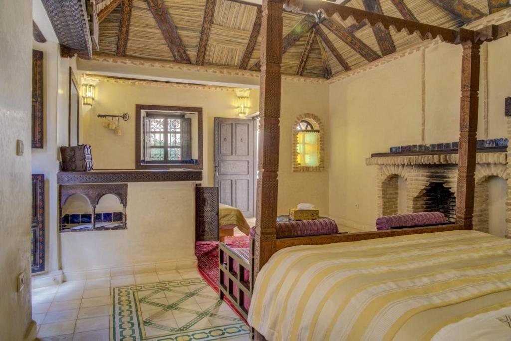 - une chambre avec un grand lit et une cheminée dans l'établissement Riad Jnane Ines, à Taroudant