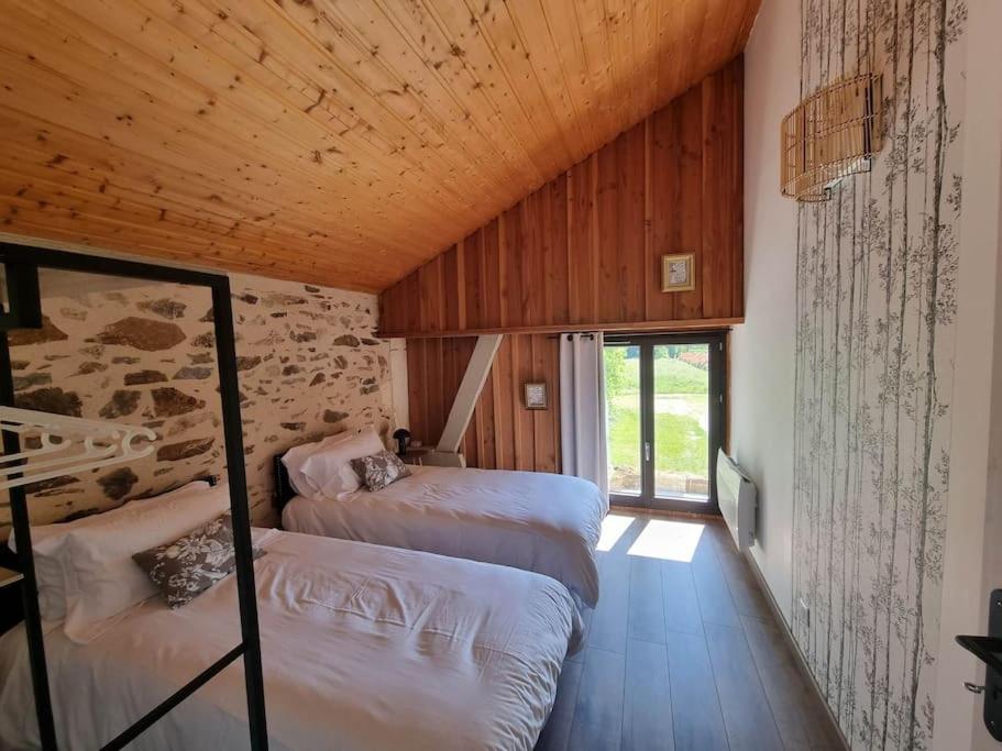 - une chambre avec 3 lits dans une pièce dotée d'un plafond en bois dans l'établissement Le Quai - Gîte atypique, à Le Châtenet