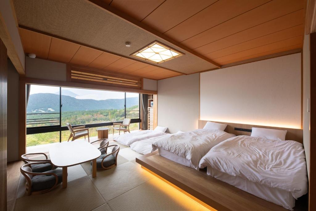 une chambre avec deux lits et une grande fenêtre dans l'établissement Hakone Ashinoko Bikeikan 箱根芦ノ湖 美景館, à Hakone