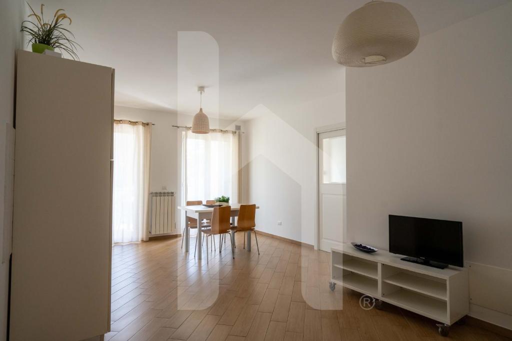 un salon avec une télévision et une table avec des chaises dans l'établissement Homiday - Residence K2, à Pineto