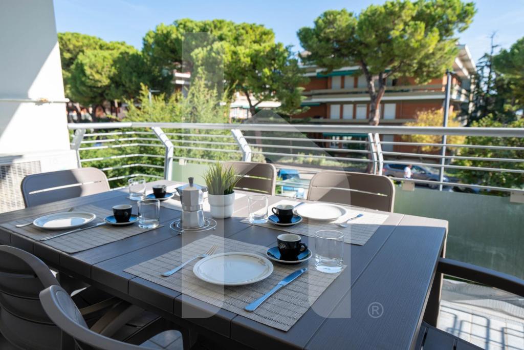 une table avec des assiettes et des verres sur un balcon dans l'établissement Homiday - Residence K2, à Pineto