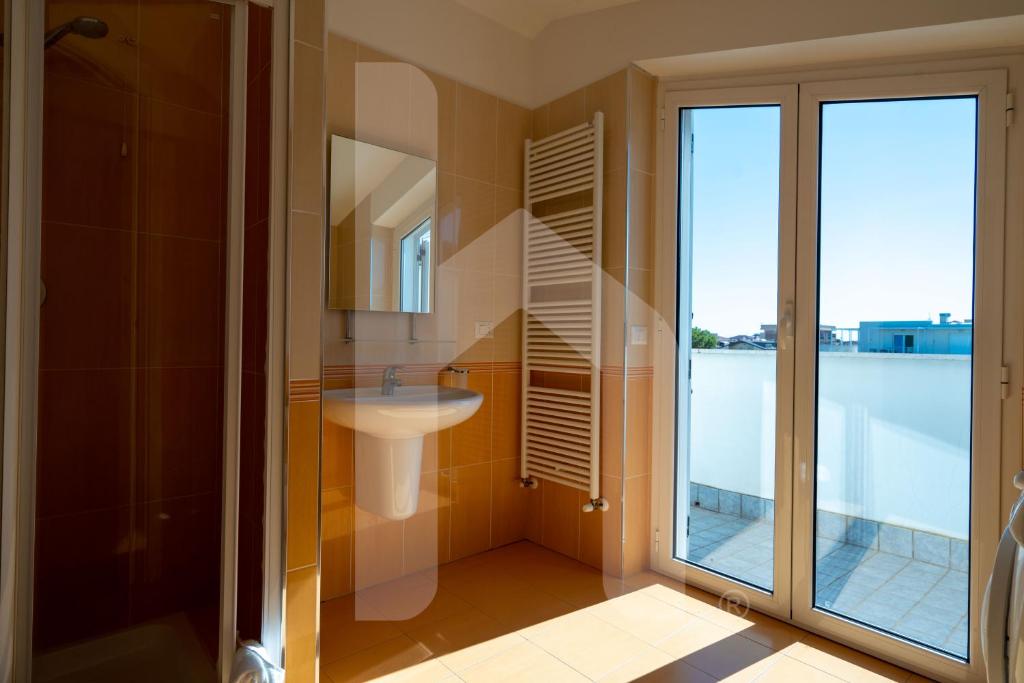 une salle de bain avec un lavabo, un miroir et une fenêtre dans l'établissement Homiday - Residence K2, à Pineto 182 autres photos