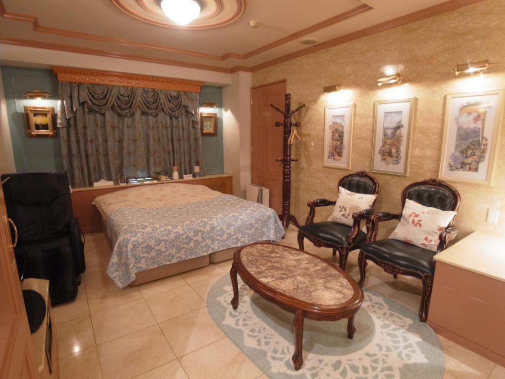 une chambre avec un lit, une table et des chaises dans l'établissement Hotel VINO Adult Only, à Kawaguchi