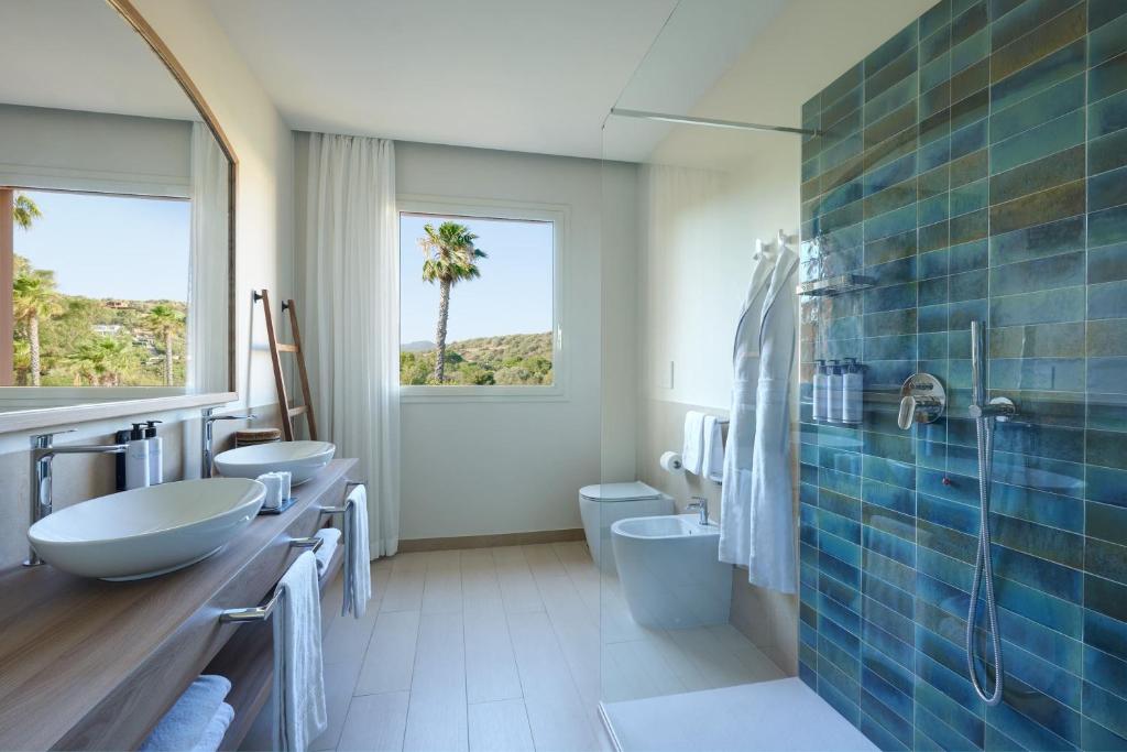 La salle de bains est pourvue de 2 lavabos et de 2 toilettes. dans l'établissement Almar Timi Ama Villasimius, à Villasimius