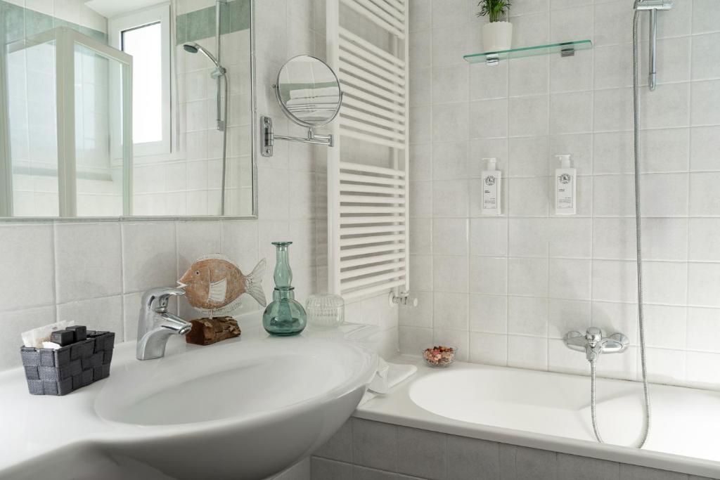 une salle de bain blanche avec un lavabo et un miroir dans l'établissement Hotel Ca' Bianca, à Riccione