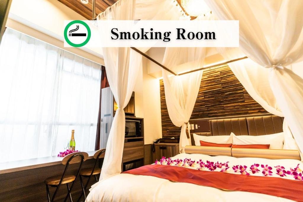 une chambre avec un lit à baldaquin et une pièce fumeurs dans l'établissement BaliAn Resort Forest Ikebukuro, à Tokyo