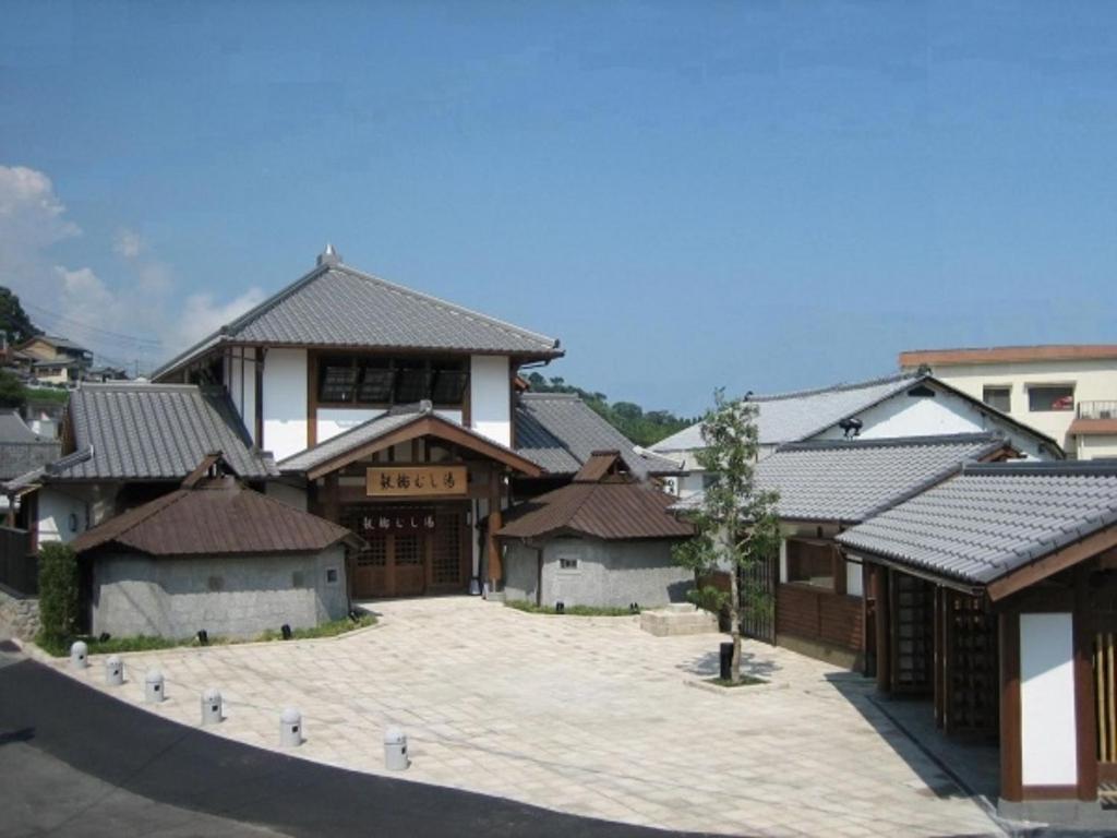 un groupe de maisons avec toits dans une rue dans l'établissement Kannawaso, à Beppu