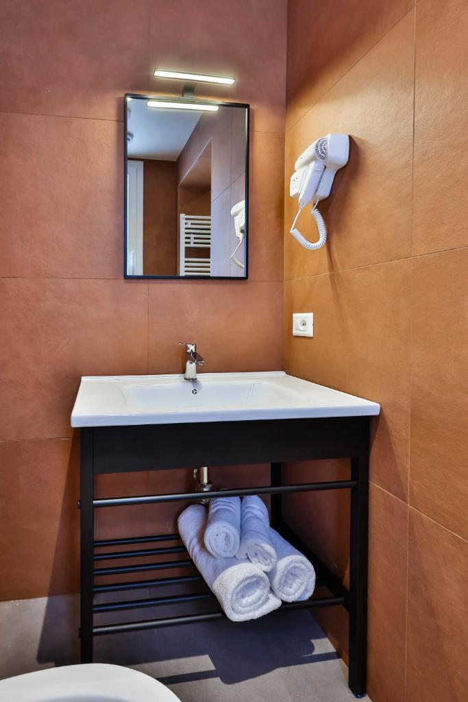 une salle de bain avec un lavabo, un miroir et des serviettes dans l'établissement Apho Apartment Hotel, à Rimini 71 autres photos