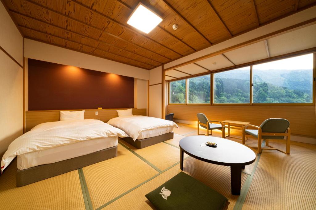 une chambre avec deux lits et une table et des chaises dans l'établissement Kurobe UnazukiOnsen Togen, à Kurobe