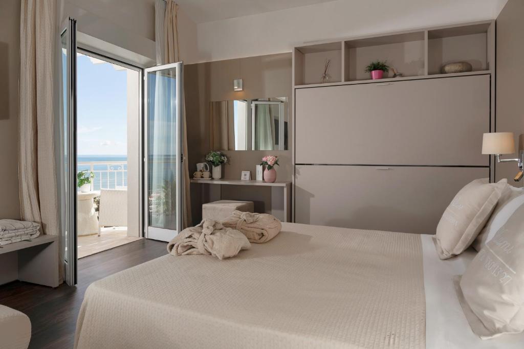 une chambre avec un grand lit blanc avec une grande fenêtre dans l'établissement Hotel Ca' Bianca, à Riccione 97 autres photos