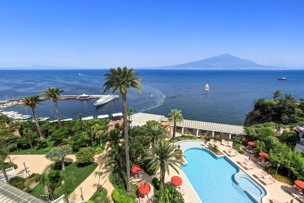 une vue aérienne d'un complexe hôtelier avec piscine et l'océan dans l'établissement Grand Hotel Royal, à Sorrente