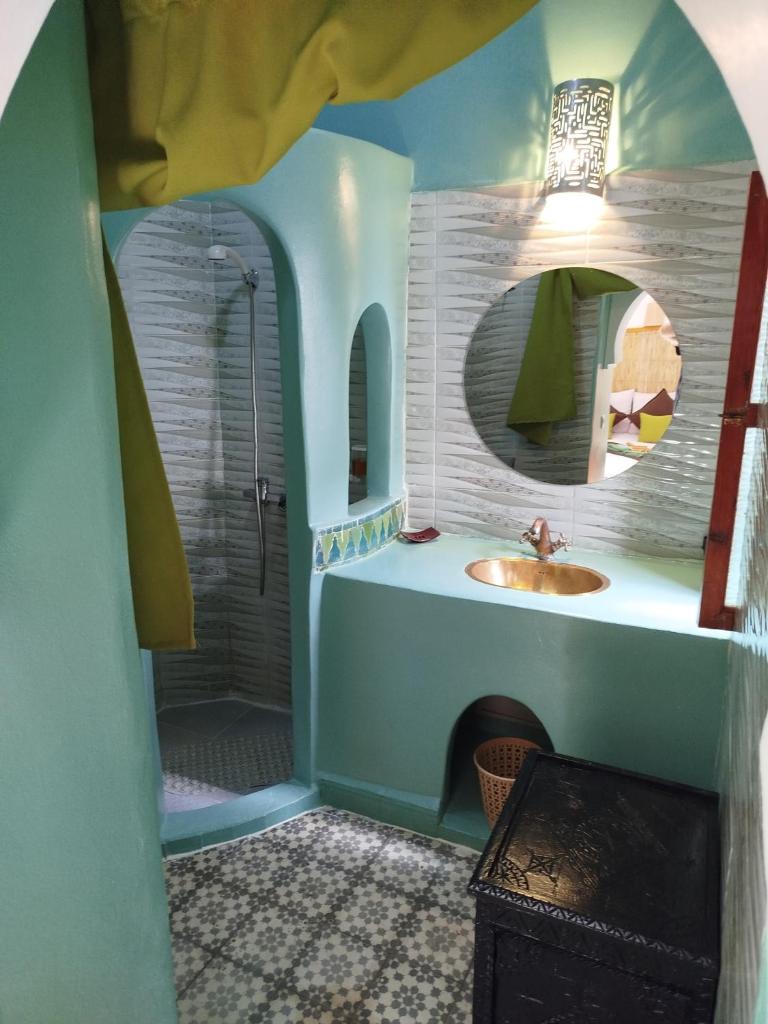 une salle de bain avec un lavabo et une douche avec un miroir dans l'établissement Riad Bab Lakhmiss, à Marrakech