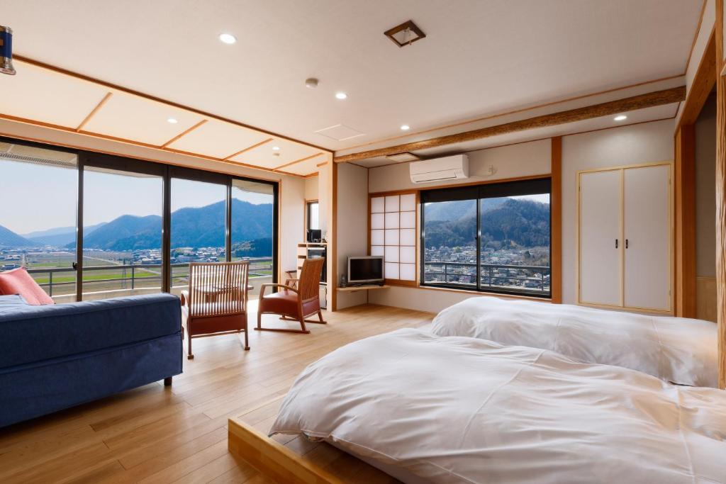 une chambre avec un grand lit et de grandes fenêtres dans l'établissement Yumenoi, à Himeji