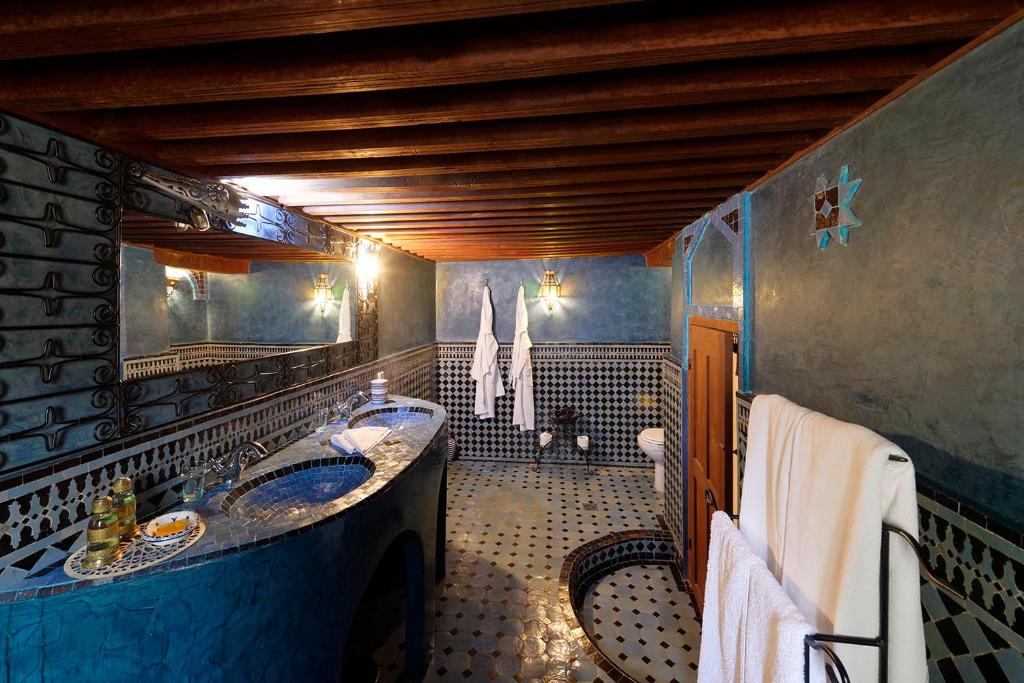 une salle de bain avec deux lavabos et une baignoire dans l'établissement Riad La Clé De Fès, à Fès