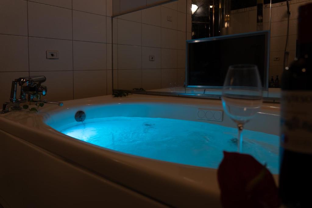 une baignoire avec un verre de vin et un verre de vin dans l'établissement M'SCLUB OsakaHirano AdultOnly, à Osaka