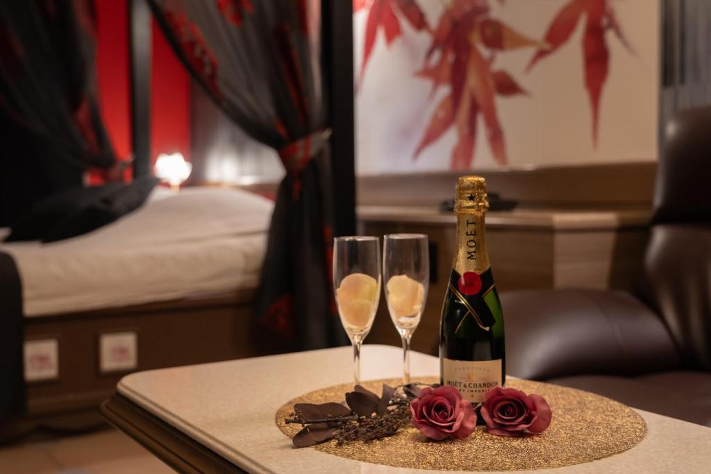 - une bouteille de champagne et deux verres sur une table dans l'établissement M'SCLUB OsakaHirano AdultOnly, à Osaka