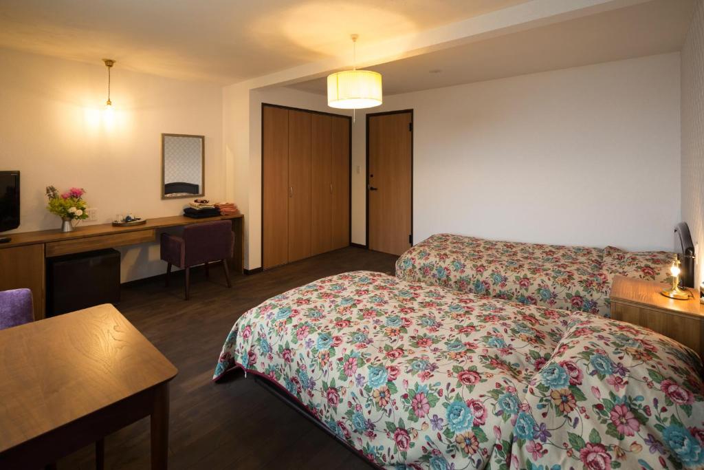 une chambre d'hôtel avec un lit et un bureau dans l'établissement SHIRETOKO Kokun Kekun, à Shari