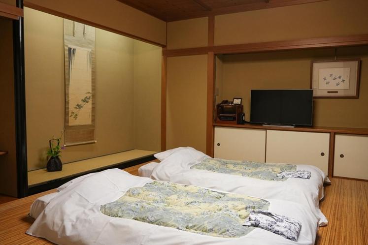 une chambre avec deux lits et une télévision à écran plat dans l'établissement Asadaya, à Kanazawa
