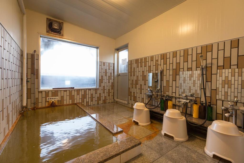 La salle de bains est pourvue d'une baignoire, de 2 toilettes et d'une fenêtre. dans l'établissement SHIRETOKO Kokun Kekun, à Shari