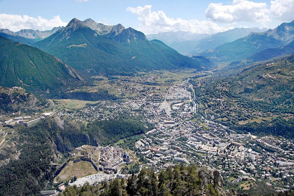 une vue aérienne sur une ville dans les montagnes dans l'établissement T3 avec terrasse plein sud au pied des télécabines, à Briançon 14 autres photos
