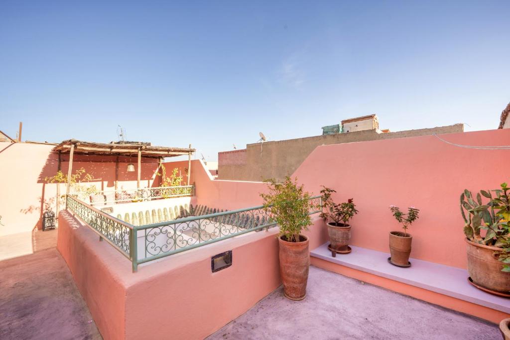 d'un balcon orné de plantes en pot sur un mur rose. dans l'établissement Riad Ghita Exclusif 15 min de Jemaa El Fnaa, à Marrakech