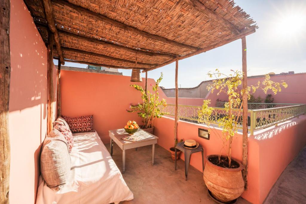 - un balcon d'une maison avec une table et un lit dans l'établissement Riad Ghita Exclusif 15 min de Jemaa El Fnaa, à Marrakech