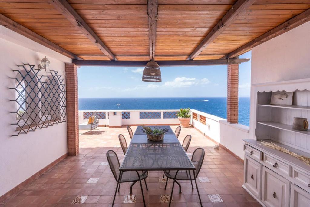 une salle à manger avec une table et une vue sur l'océan dans l'établissement Villa Dafne Gulf Views Pool and Guest Services by Feeling Italy, à Massa Lubrense