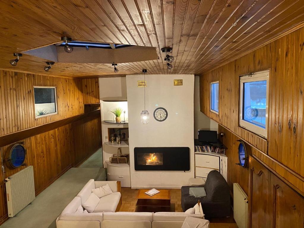 un salon avec un canapé et une cheminée dans l'établissement Péniche Amadeus conviviale et cosy , proche de Disney et de Paris, à Torcy