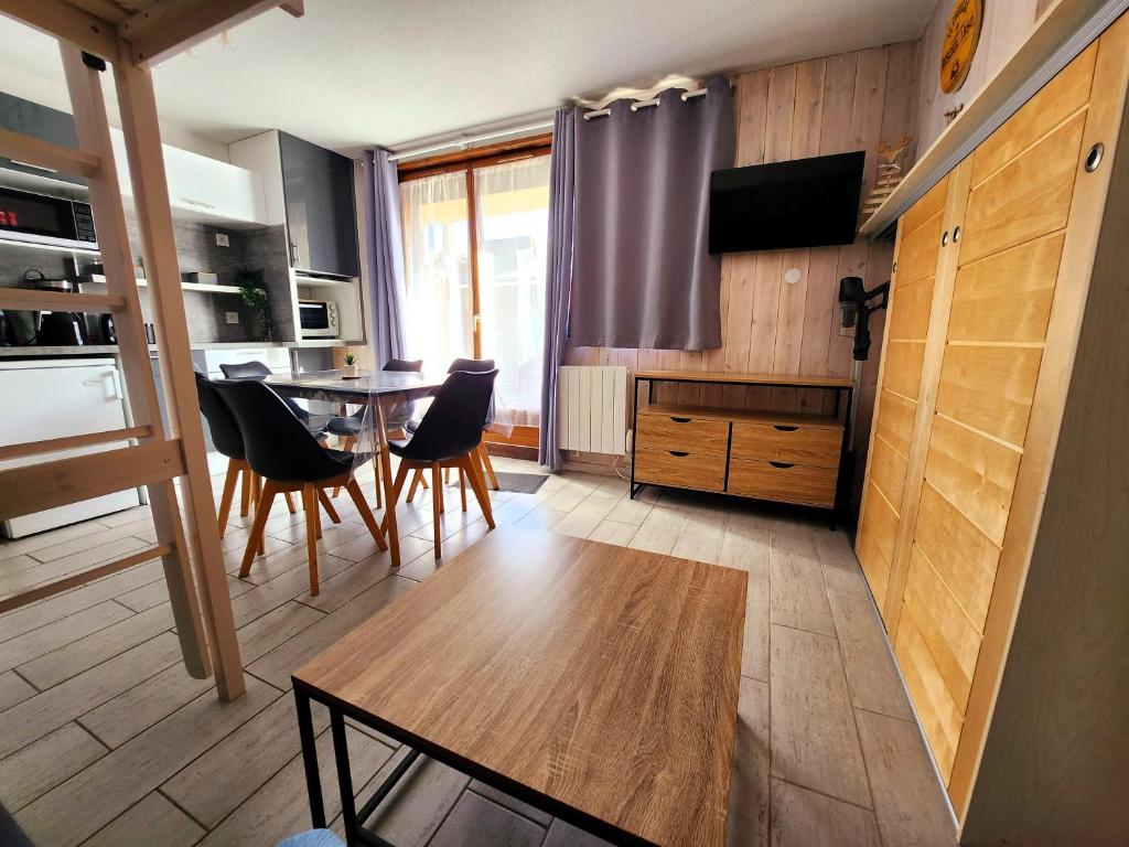 une cuisine et une salle à manger avec une table et des chaises dans l'établissement Le Choucas, à Risoul