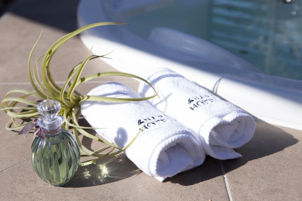 - deux serviettes roulées à côté d'une bouteille de verre dans l'établissement ホテルパサディナ富山, à Toyama