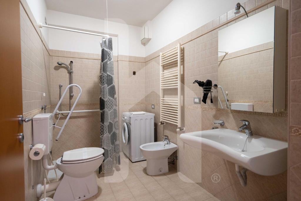 une salle de bain avec toilettes, lavabo et miroir dans l'établissement Homiday - Holiday Rendez Vous, à Pineto