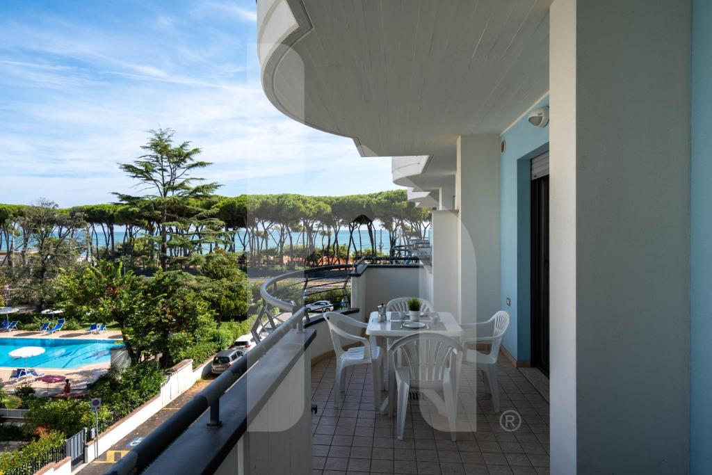 un balcon avec une table et des chaises et une piscine dans l'établissement Homiday - Holiday Rendez Vous, à Pineto