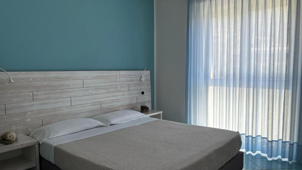 une chambre avec un lit et une grande fenêtre dans l'établissement Ancora Resort, à Acciaroli 93 autres photos