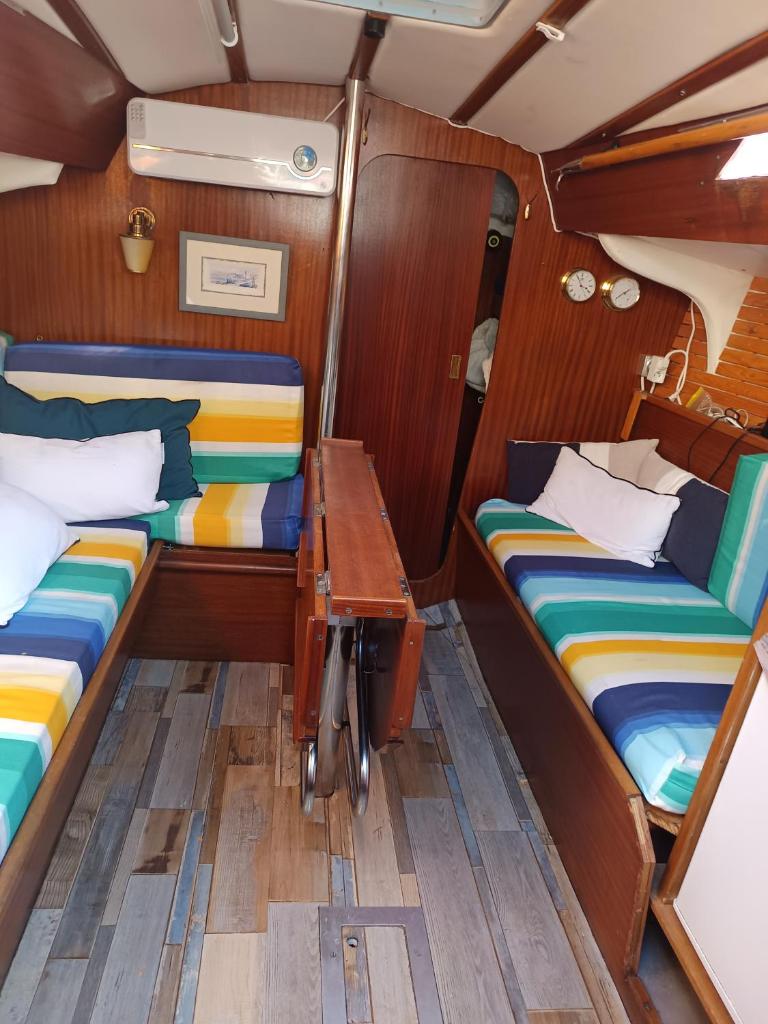 une petite chambre avec deux lits et une table dans l'établissement Orion, au Barcarès