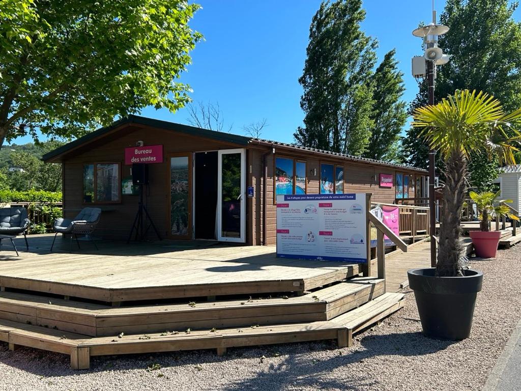 un petit bâtiment avec un panneau devant lui dans l'établissement Le Paradis du Rhône - mobilhome moderne et confortable, à Condrieu