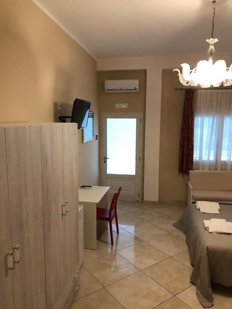 Cette chambre comprend un lit, une table et un bureau. dans l'établissement Hotel Borina by Isola dei sapori, à Foce Varano