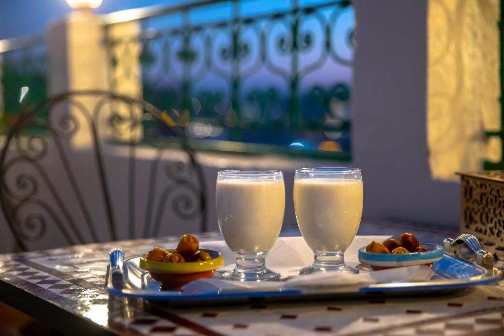 deux verres de lait et une assiette de nourriture sur une table dans l'établissement Riad Bahja Fez, à Fès