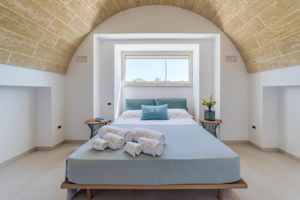 une chambre avec un lit avec des serviettes dessus dans l'établissement VILLA FLORI', à Marina di Pescoluse