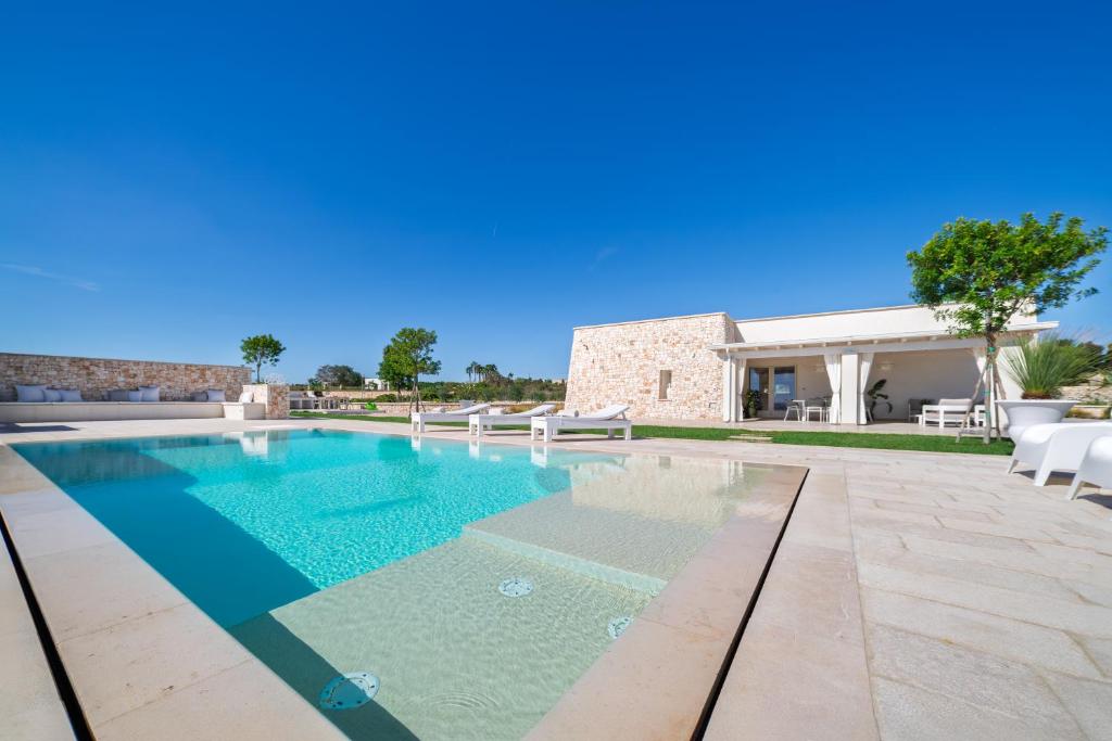 une piscine avec des chaises et une maison dans l'établissement VILLA FLORI', à Marina di Pescoluse