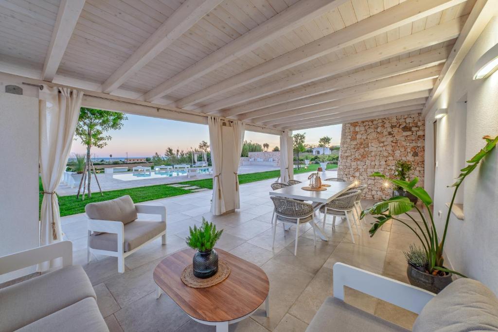 Elle comprend une terrasse dotée d'un mobilier blanc, d'une table et de chaises. dans l'établissement VILLA FLORI', à Marina di Pescoluse