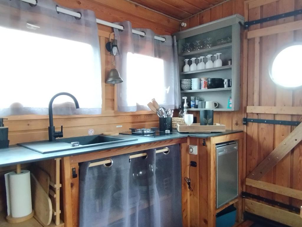 une cuisine avec des armoires en bois et un évier dans l'établissement La Toue Charme, à Angers