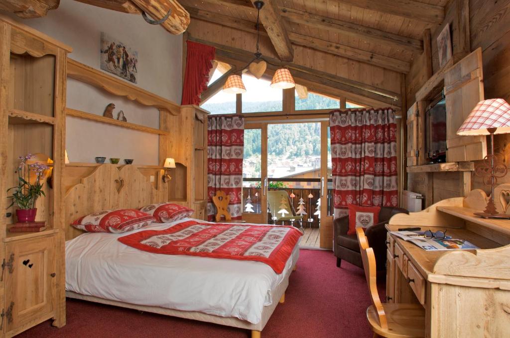 une chambre avec un lit et un bureau dans une pièce dans l'établissement Hotel L'Equipe, à Morzine