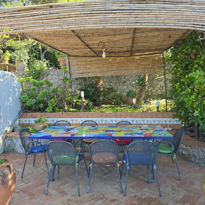 une table et des chaises assises sous une pergola dans l'établissement Casa Infinito, à Capri