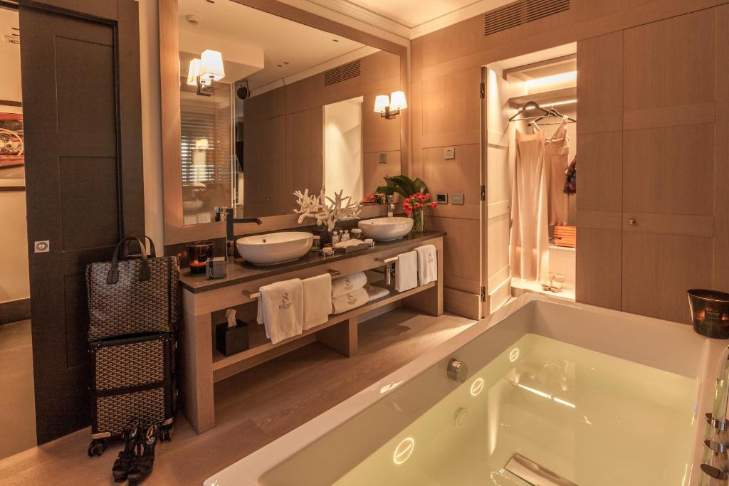 une salle de bain avec une grande baignoire et un grand miroir dans l'établissement Eight Hotel Paraggi, à Santa Margherita Ligure