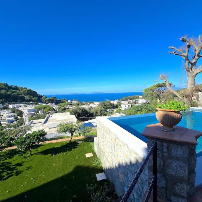 un vase assis sur un mur à côté d'une piscine dans l'établissement Casa Infinito, à Capri