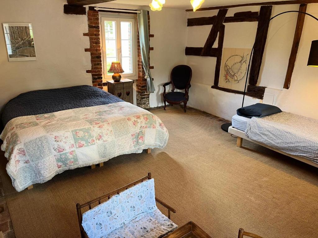 une chambre avec deux lits et une chaise dans l'établissement Domaine de l'Atrée - Gite La Petite Longère dans la Nature Préservée, à Saint-Martin-des-Champs