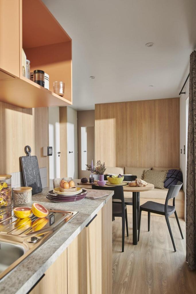 une cuisine et une salle à manger avec une table et des chaises dans l'établissement MAS DES LAVANDES, à Sérignan
